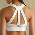 White athletic sports bra with intricate crisscross back straps and mesh panel beneath in a navy blue mesh high impact bra
