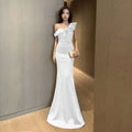 A sleek white satin mermaid gown with a single shoulder ruffle detail inspired by celebrity french style