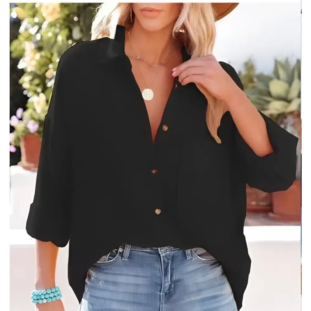 Black button-up blouse with three-quarter sleeves and relaxed fit paired with navy dropped shoulder bat shirt detail