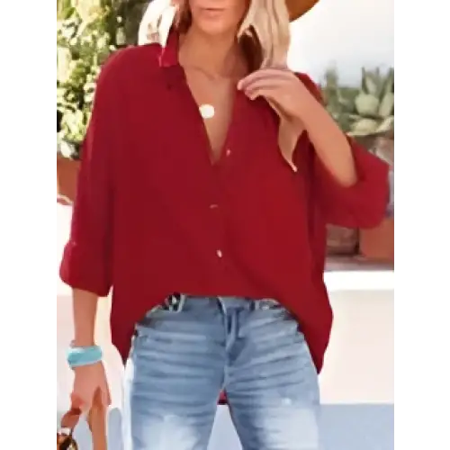 Red button-up blouse with rolled sleeves and relaxed fit styled as navy dropped shoulder bat shirt casual long sleeve