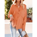 Orange button-up blouse with rolled sleeves and relaxed fit paired with navy dropped shoulder bat shirt long sleeve