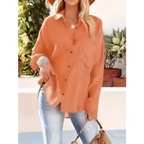 Orange button-up blouse with rolled sleeves and relaxed fit paired with navy dropped shoulder bat shirt long sleeve