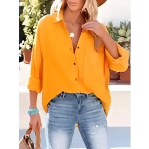 Yellow button-up blouse with rolled sleeves and relaxed fit contrasting the navy dropped shoulder bat shirt long sleeve design