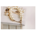 Navy pearl flower bracelet with cream-colored pearls gold-toned chain and gold horse charm detailing