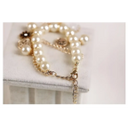 Navy pearl flower bracelet with cream-colored pearls gold-toned chain and gold horse charm detailing