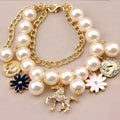 Navy pearl flower bracelet featuring cream-colored pearls and a gold horse charm with navy and white floral accents