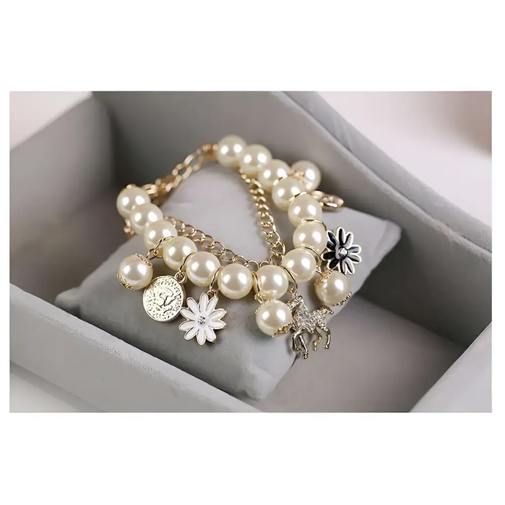Navy pearl flower bracelet with cream-colored pearls and gold horse charm featuring white flower and silver coin charms