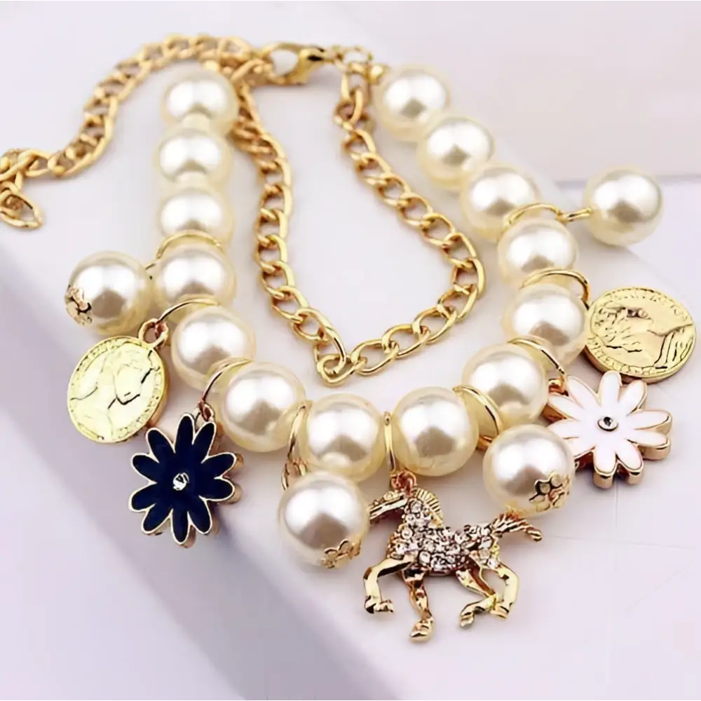 Gold-toned necklace with cream-colored pearls, pearl flower bracelet strands, and a gold horse charm pendant