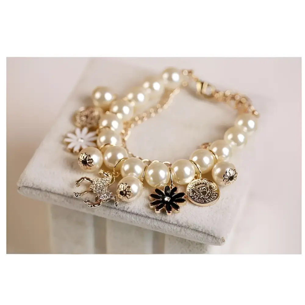 Navy pearl flower bracelet featuring cream-colored pearls and a delicate gold horse charm with intricate black flower details