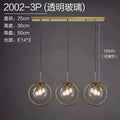 Gold-toned nordic modern minimalist glass pendant light with three transparent glass spheres suspended from a brass bar