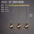 Modern three-light glass pendant light with smoked globes and gold-toned rings in nordic modern minimalist style