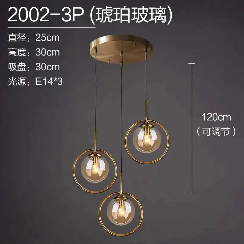 Gold-toned nordic modern minimalist glass pendant light with three spherical bulbs in brushed brass adjustable frames