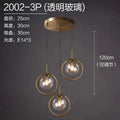 Nordic modern minimalist glass pendant light with brass finish and three transparent globe shades on adjustable cords