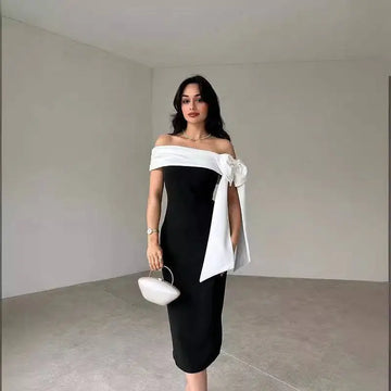 Black off-shoulder color matching elegant cocktail dress with white fabric bow detail and matching white clutch purse