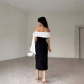 Black off-shoulder color matching elegant cocktail dress with white fabric sash draped over one shoulder