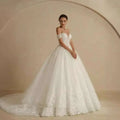 A white off-shoulder lace bridal gown with intricate lace detailing and a voluminous skirt for weddings