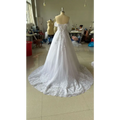 A white off-shoulder lace bridal gown with intricate lace detailing and a flowing skirt displayed on a mannequin