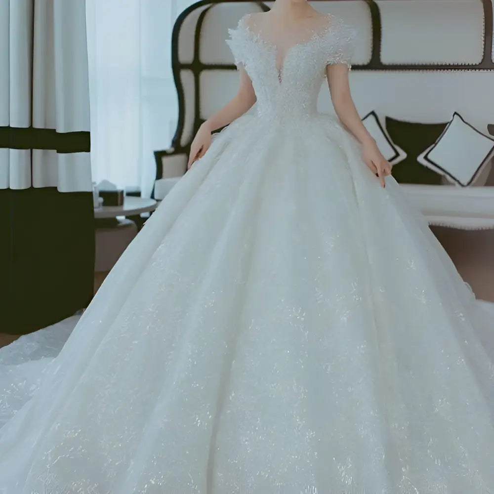 A sparkling white lace wedding dress with off shoulder design and voluminous skirt perfect as a dress piece set