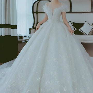 A sparkling white lace wedding dress with off shoulder design and voluminous skirt perfect as a dress piece set