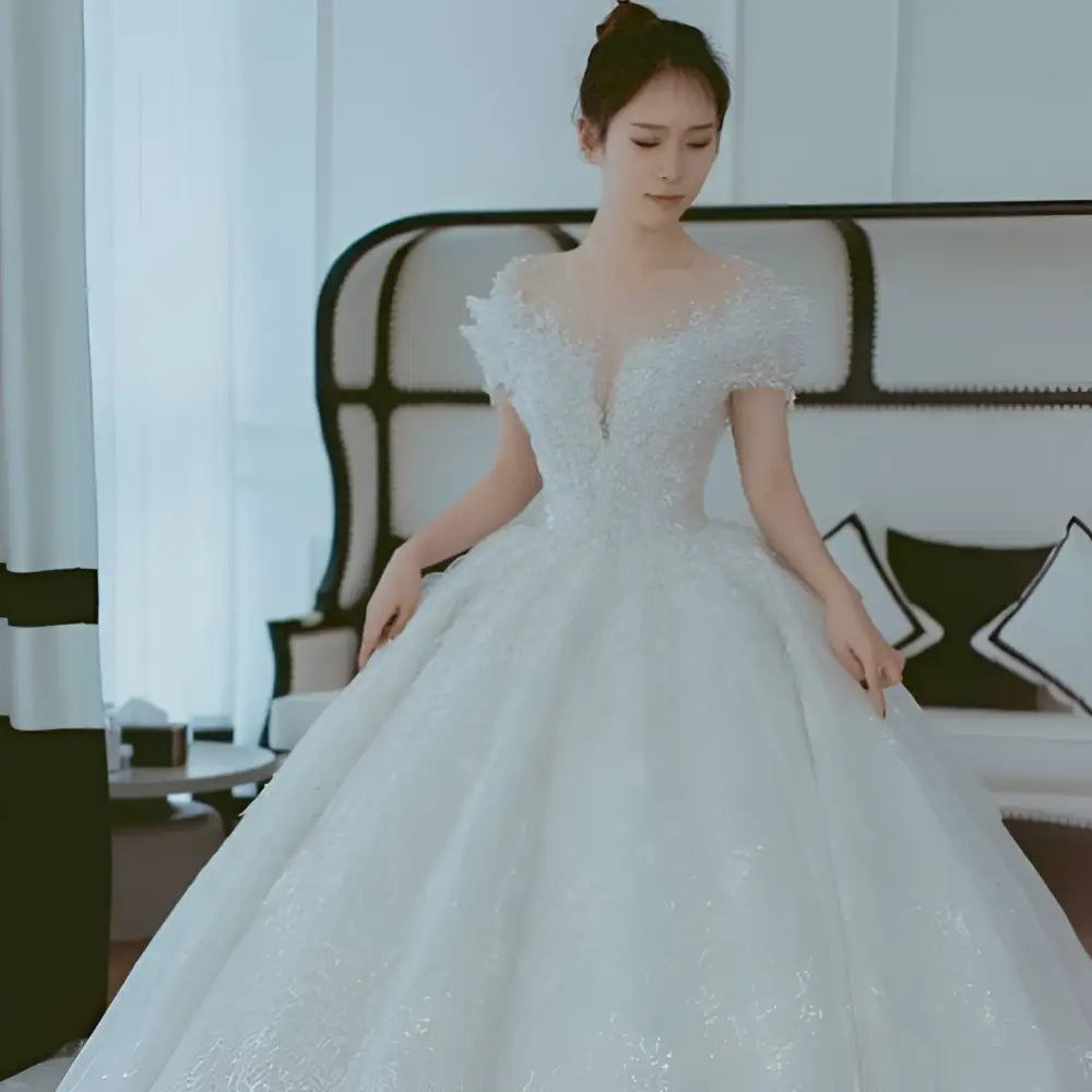 A sparkling white lace wedding dress with off shoulder design and voluminous skirt perfect as a dress piece set