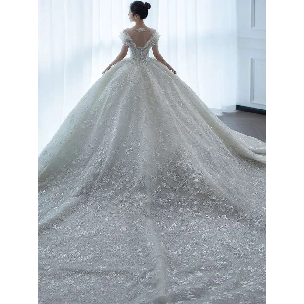 Off shoulder lace wedding dress in white featuring lace material and a voluminous skirt perfect for bridal wear