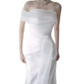 Off-shoulder satin light wedding dress with a fitted bodice and flowing white fabric draped elegantly