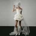 Off-shoulder tulle white mini dress with puffed skirt and sheer veil as a white wedding dress with train