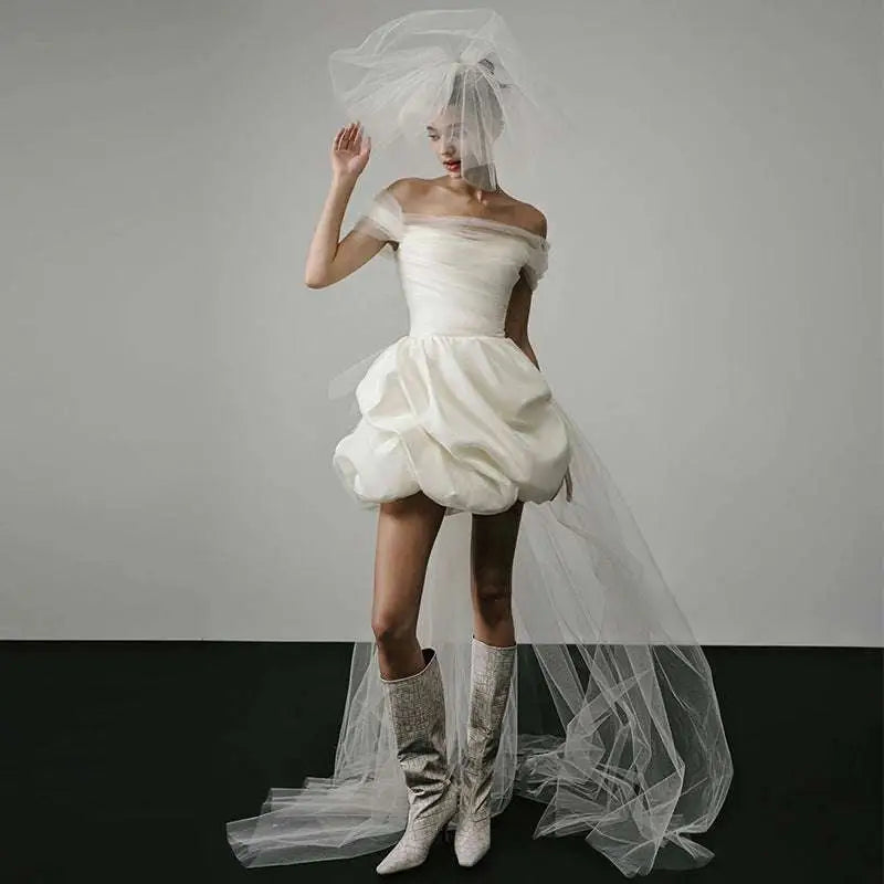 Off-shoulder tulle white mini dress with puffed skirt and sheer veil as a white wedding dress with train