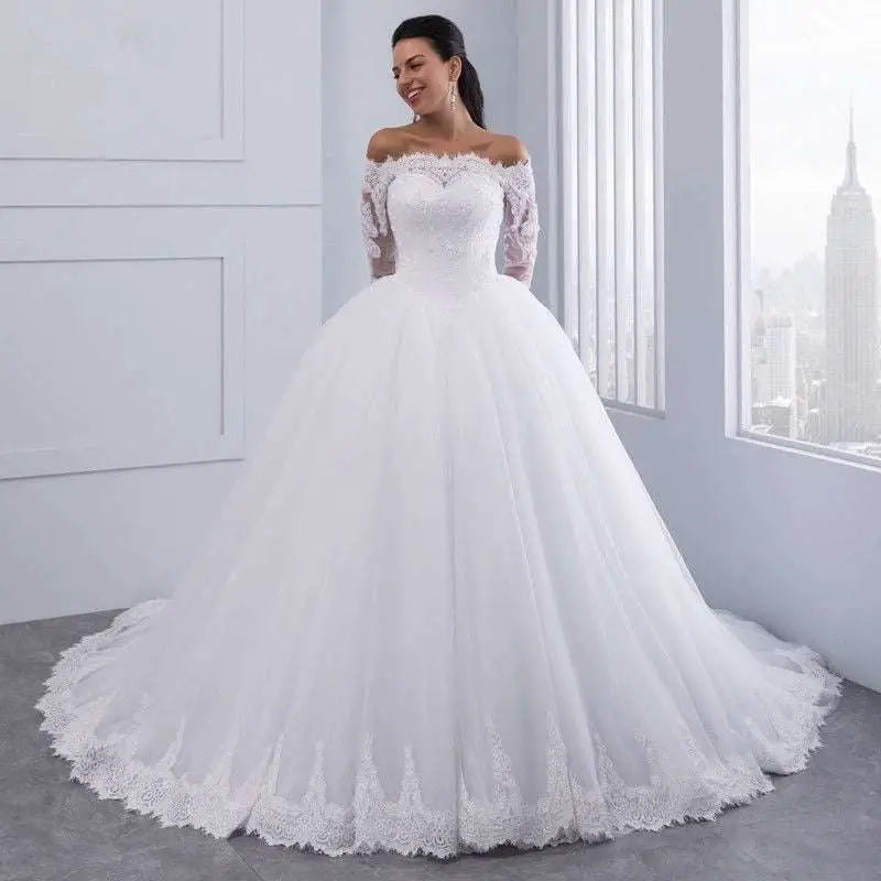 White off-the-shoulder bridal wedding lace gown with long lace sleeves and voluminous tulle skirt with floral embroidery