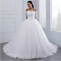 A white off-the-shoulder bridal wedding lace gown with long sleeves and a voluminous tulle skirt perfect for weddings