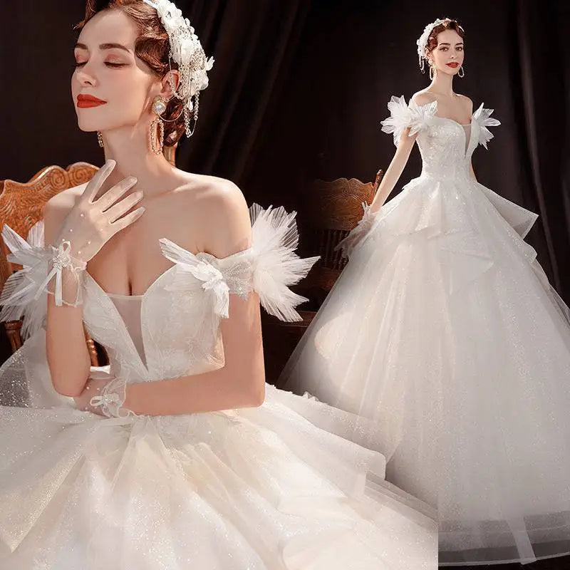 Elegant white off the shoulder lace tulle wedding dress with delicate detailing and a voluminous sparkling tulle skirt