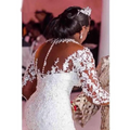 A woman wears an off the shoulder long sleeves mermaid white wedding dress with intricate floral lace embroidery
