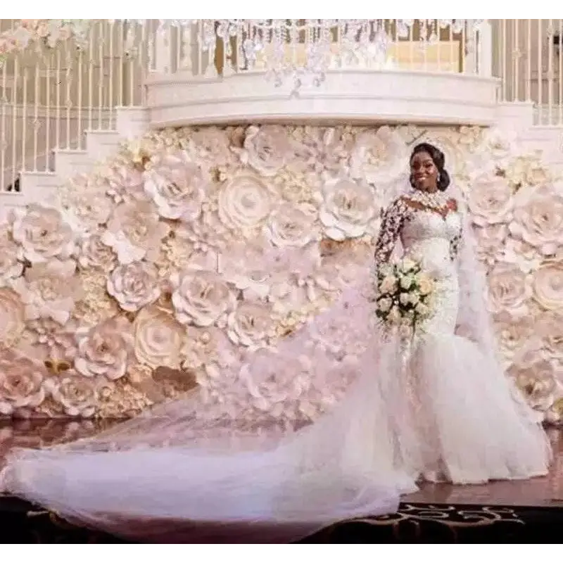 A bride wearing a long sleeves mermaid white wedding dress with off the shoulder neckline and holding a bouquet