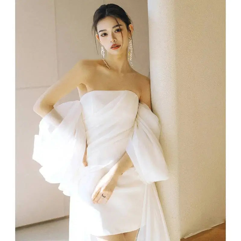 Off the shoulder mini light wedding dress in white with sheer puff sleeves and fitted skirt for small light wedding events