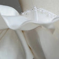 Off the shoulder satin light wedding dress with delicate white satin ruffle adorned with pearls and tiny crystals