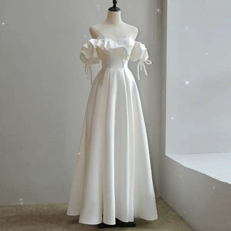 Off the shoulder satin light wedding dress in white with puffed sleeves and delicate tie details