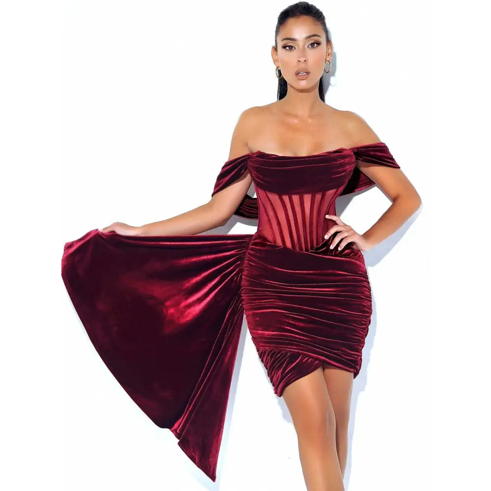 A deep burgundy off the shoulder velvet sexy evening mini dress with a ruched corset bodice and flowing side panel