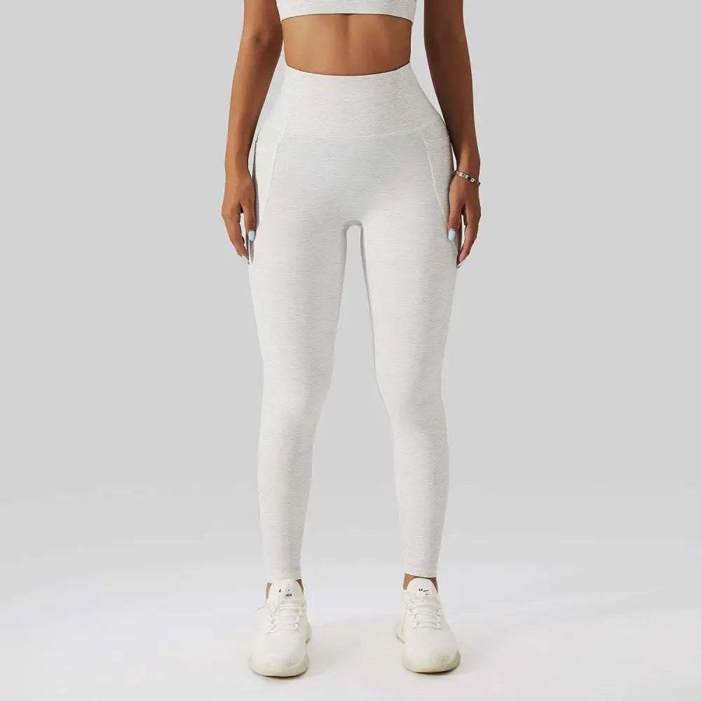 White high-waisted leggings with textured form-fitting design paired with olive green yoga bra fitness suit with pockets