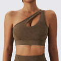 A sleek olive green yoga bra fitness suit featuring a one-shoulder asymmetrical cutout and textured fabric