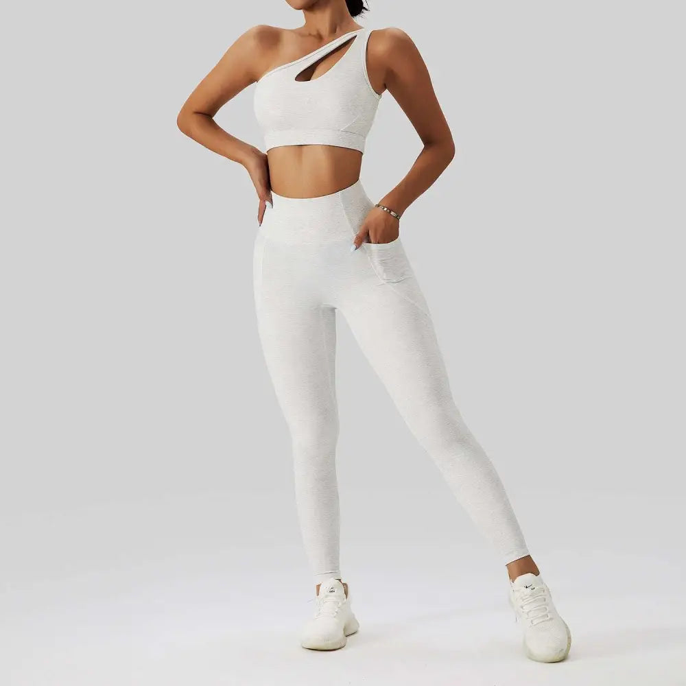 White one-shoulder crop top with cutout detail and matching high-waisted leggings in olive green yoga bra fitness suit with pockets