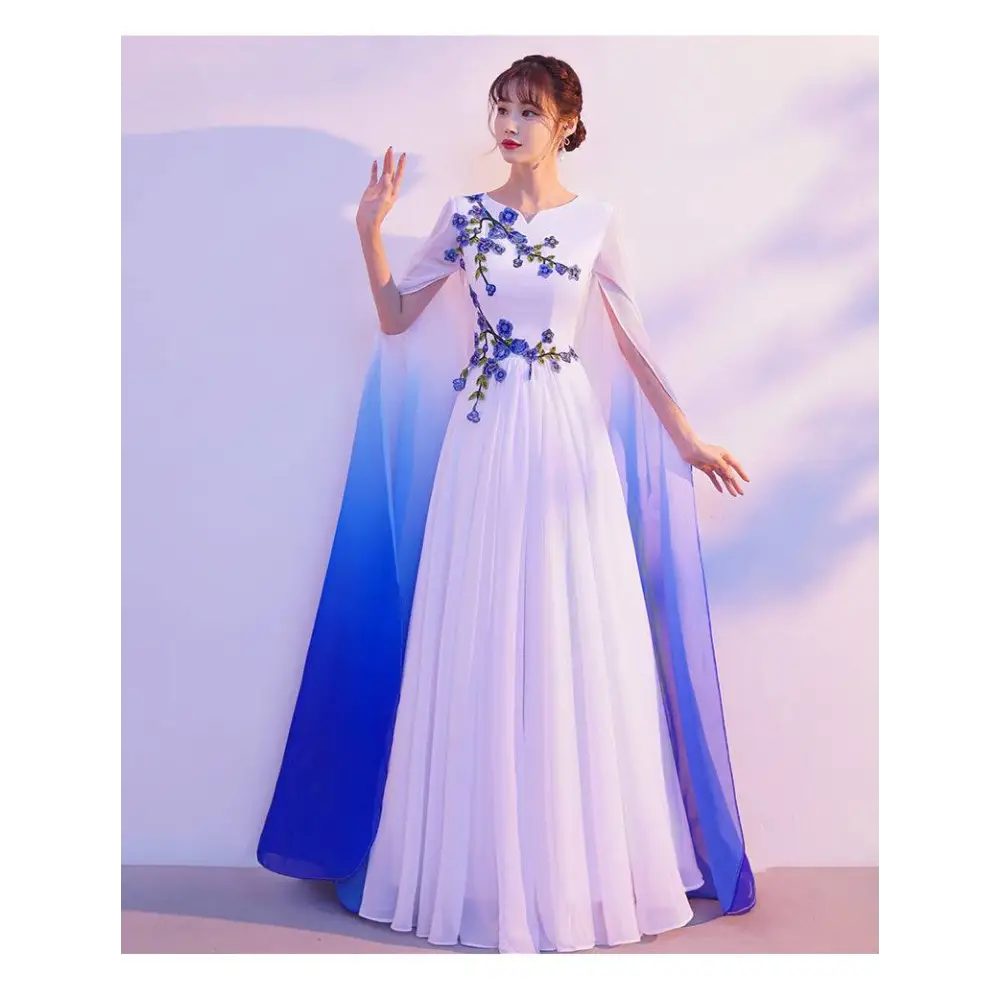 White flowing floral choral dress with blue embroidery and ombre cape for red song competition performance