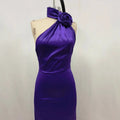 A sleek fitted high waist one shoulder rose gown in waist purple satin with a matching fabric rose at the neckline