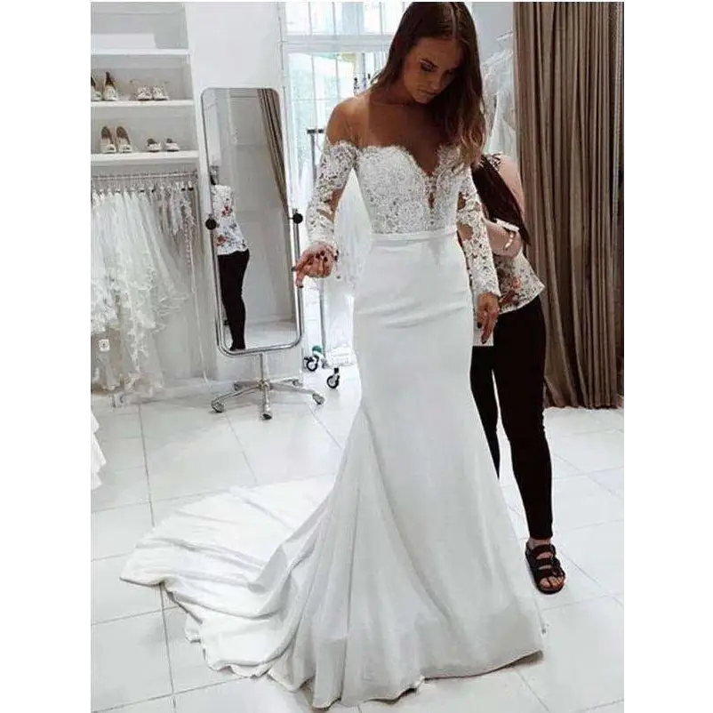White mermaid wedding dress with lace long sleeve off-the-shoulder bodice and fitted silhouette with flowing train