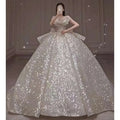 A shimmering white one-shoulder wedding dress with long trailing heavy industry sequin bodice and off-the-shoulder design