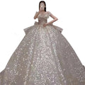 A shimmering silver sequined one-shoulder wedding dress with a fitted bodice and long trailing heavy skirt