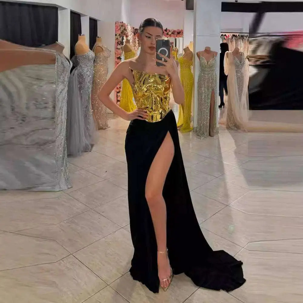 A shimmering gold and black one-shoulder slit mop dress two-piece set with a structured embellished bodice and flowing skirt