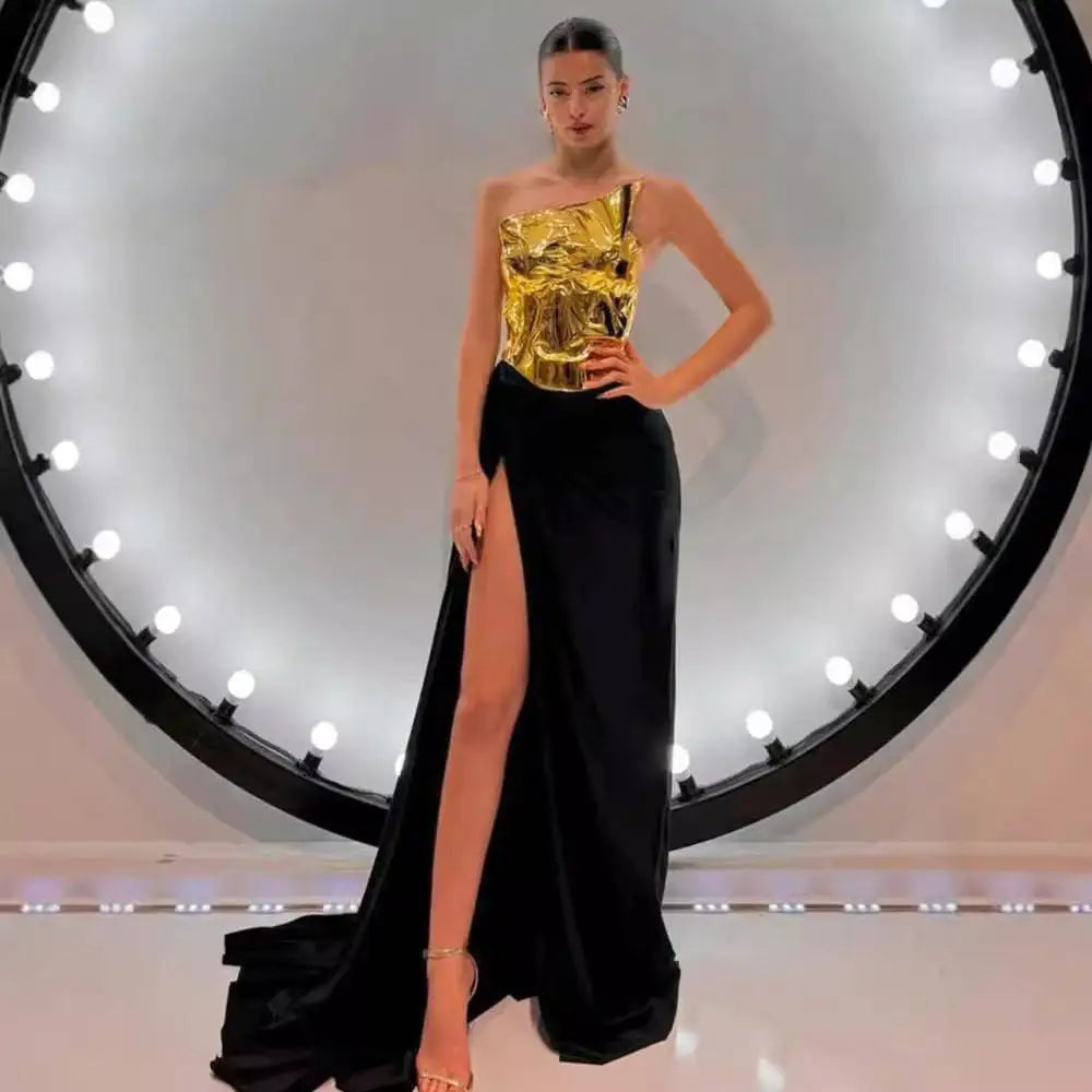 One-shoulder slit mop black dress two-piece set with glossy gold metallic bodice and flowing black satin skirt with high slit