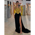 A one-shoulder slit mop black dress two-piece set with a metallic gold bodice and flowing black skirt featuring a high slit