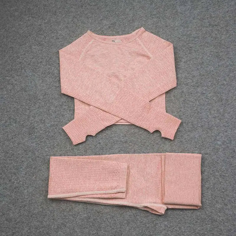 A soft blush pink long-sleeved cropped sweater with textured knit and ribbed cuffs in an orange jacquard seamless yoga set