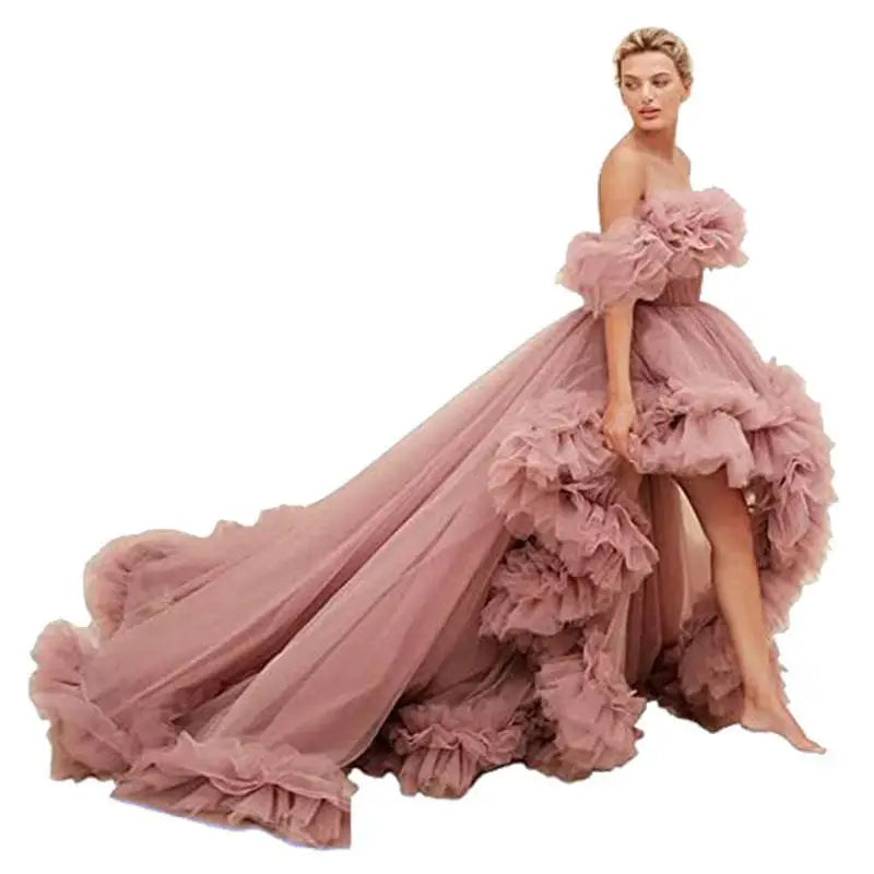 A flowing dusty rose tulle luxury women’s fashion high low gown with layered ruffles and off the shoulder design